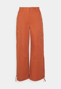 Wide-leg cargo pants in burnt orange, made of cotton blend. Features side pockets, adjustable hems, and a button and elastic waistband.