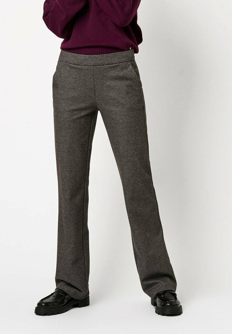 Gray tailored trousers in a textured fabric, featuring a fitted waist and slight flare at the hem, paired with black shoes.