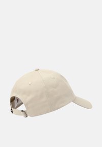 Beige baseball cap lavet af bomuld med en buet skygge, justerbar rem og broderet logo på bagsiden med stribede detaljer.