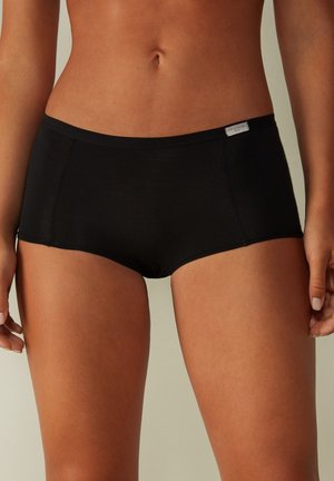 Zwarte hipster-stijl onderbroek gemaakt van een gladde stof met een aansluitend ontwerp, voorzien van minimale naden en een klein label op de tailleband.