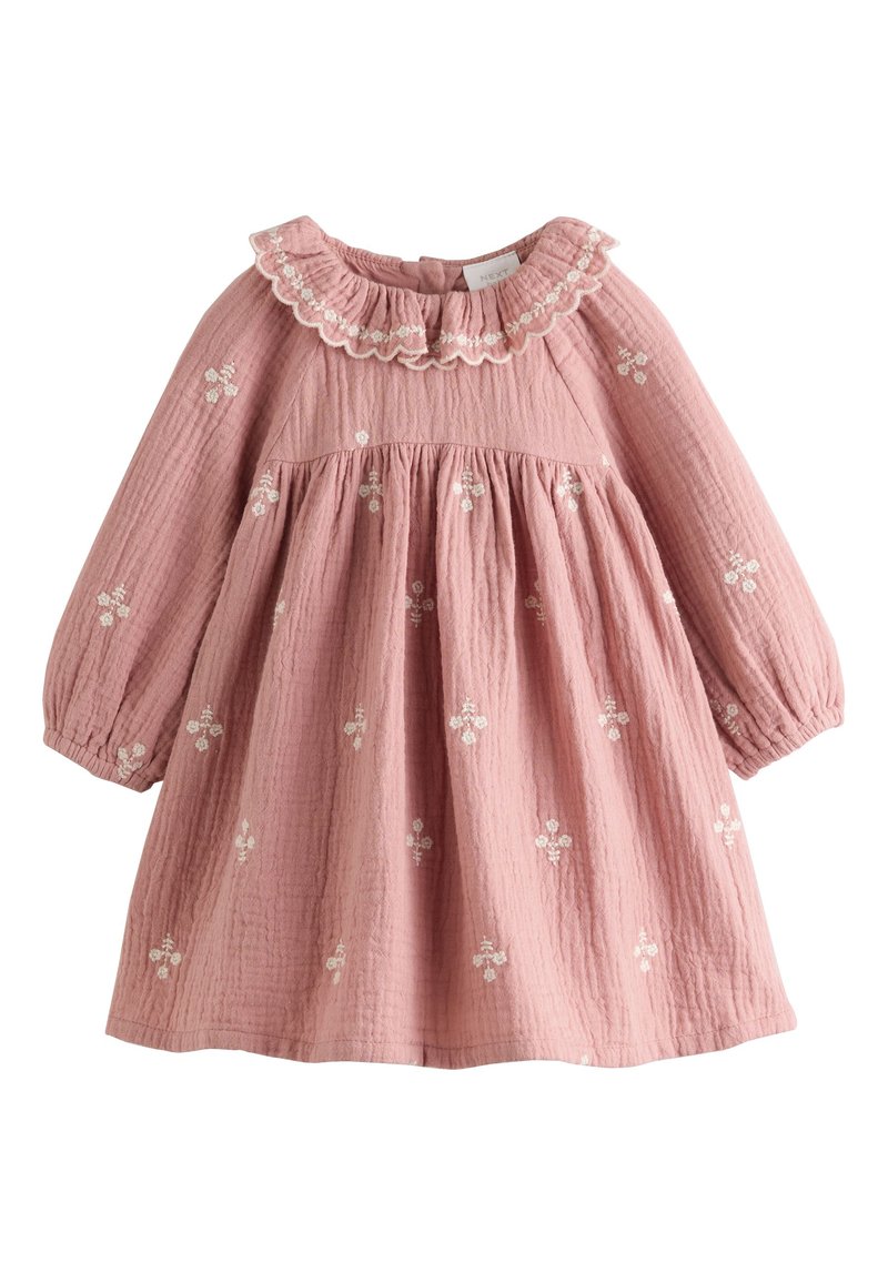 Vestito rosa in cotone con maniche lunghe, collo arricciato e ricamo floreale bianco. Tessuto strutturato con corpetto arricciato e gonna ampia.