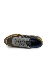 Basket gris et jaune avec tige en textile mesh, accents en daim, lacets ronds et semelle en caoutchouc. Présente le logo de la marque sur le côté.