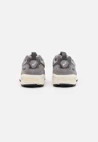 Grijze suède en mesh sneakers met zwarte accenten. Licht gebogen hak, ontworpen met een padded kraag en logo detail. Rubberen zool.