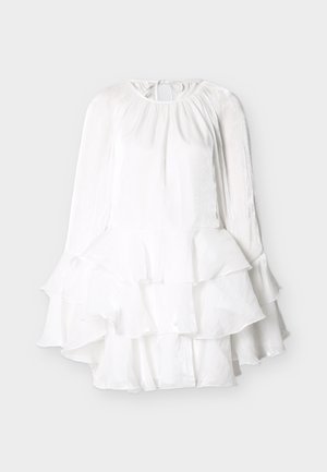 Robe blanche à manches longues avec col rond à nouer, corsage froncé et jupe à volants étagée en tissu léger texturé.