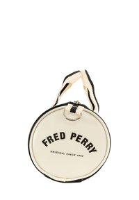 Rund, cremefarvet taske med sorte detaljer. Funktioner "FRED PERRY" tekst og en sølvfarvet hardware ring. Tekstureret stof med robust håndtag.