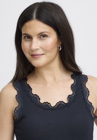 Črna majica brez rokavov z čipkastim robom okoli izreza in naramnic, rebraste teksture in oprijete zasnove.