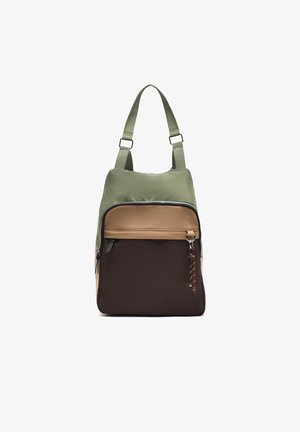 Batoh s nastaviteľnými popruhmi v olivovo zelenej, pieskovej a tmavo hnedej farebnej kombinácii, s predným vreckom na zips a detailom zaveseného kľúčenky.