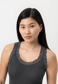 Donkergrijze geribde tanktop met kantafwerking op de halslijn en schouderbandjes. De stof lijkt zacht met een gestructureerde afwerking. Geen andere details zichtbaar.