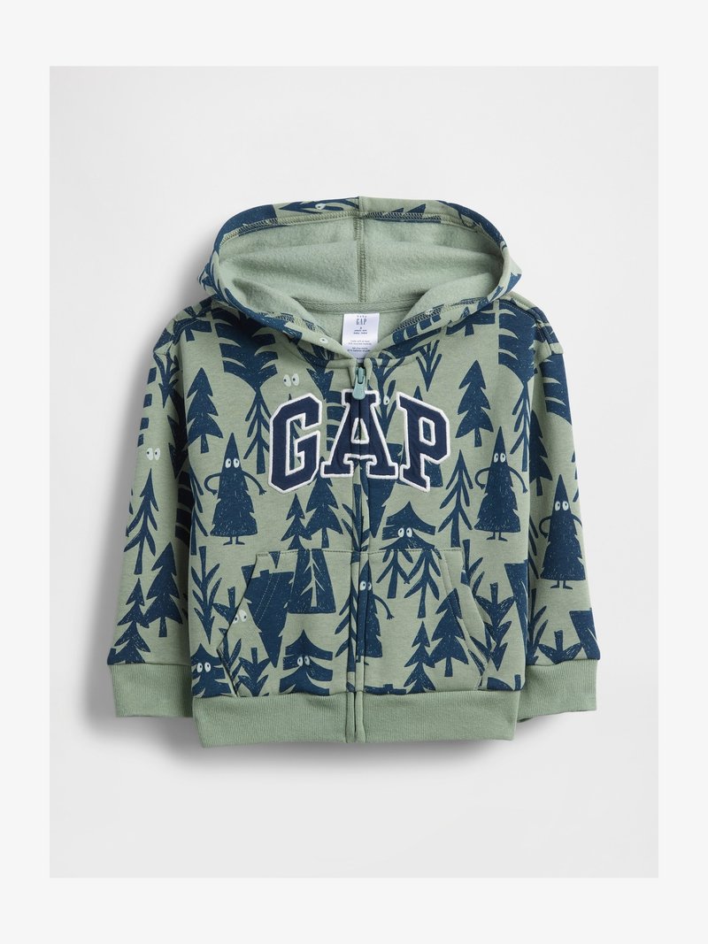 Hanorac verde pentru copii cu fermoar, cu modele de copaci albastre închis și ochi albi, având inscripția mare "GAP" pe piept și buzunarele din față.