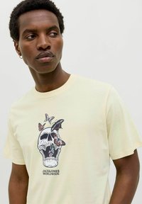Geel katoen t-shirt met een grafische print van een schedel met vlinders. Korte mouwen en ontwerp met ronde hals.