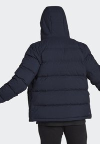 Puffig marinblå jacka med huva, med quiltade sektioner, långa ärmar och boxig passform. Slät textur och minimalistisk design.