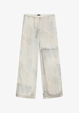 Lekkość i szeroki krój spodni w stonowanym beżowym kolorze z delikatną fakturą i subtelnym połyskiem. Wyposażone w elastyczny pas dla komfortu.