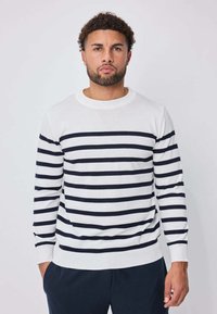 Pull blanc à rayures horizontales bleu marine, col rond côtelé et manches longues. Confectionné dans un matériau doux, avec une coupe ajustée.