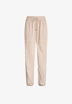 Pantaloni beige chiaro con coulisse in vita, gamba affusolata e orli arricciati, realizzati in un materiale leggero e liscio.