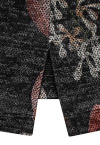 Schwarzer Strickstoff mit einem floralen Muster in gedämpften Tönen. Das Design hat eine strukturierte Oberfläche und einen kleinen Schlitz am unteren Ende.