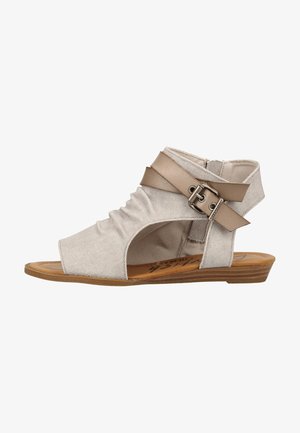 Beige Stoff-Sandalette mit offener Zehenpartie und einem niedrigen Holzsohle, mit gerafften Seiten und einem doppelten, tan-farbenen Leder-Riemen am Knöchel mit einer Metallschnalle.