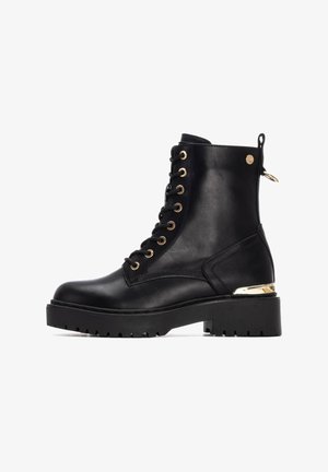 Stivaletto in pelle nera con punta rotonda, occhielli dorati, suola spessa nera e accentuazione metallica sul tallone. Design con lacci e finitura testurizzata.