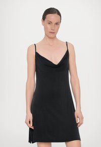 Rochie neagră fără mâneci, cu un decolteu drapat și bretele ajustabile. Țesătură netedă și moale, cu o croială lejeră și o fanta subtilă pe lateral.