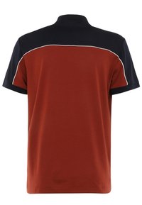 Kortärmad polo i rostfärg, med marinblå krage och axelaccenter samt vit kantning längs sömmarna. Slät bomullstextur.