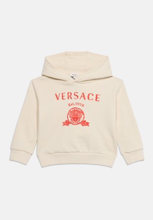 Mikina s kapucňou v krémovej farbe s červeným logom Versace, hlavou Medúzy a textom "Est. 1978" na prednej strane, položená na bielom pozadí.