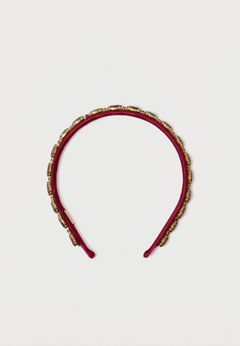 Červená velvetová čelenka zdobená obdĺžnikovými zlatými akcentmi pozdĺž okraja, s hladkou textúrou a zaobleným tvarom.