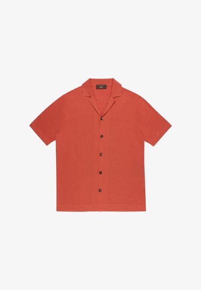 Chemise terracotta à manches courtes avec boutons, col camp et boutons foncés, étalée à plat sur un fond blanc.