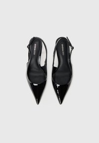 Sorte patentlæder slingback hæle med spidse tær, en glat overflade, justerbar ankelrem og polstrede indersåler.