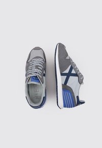 Zapatillas en gris y azul, con una parte superior de malla y acentos de ante. Presentan cordones, plantilla acolchada y una suela de goma texturizada para mayor tracción.