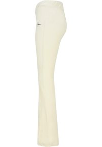 Cream-colored flared pants with a soft texture, elastic waistband, and a small embroidered logo on the left side.