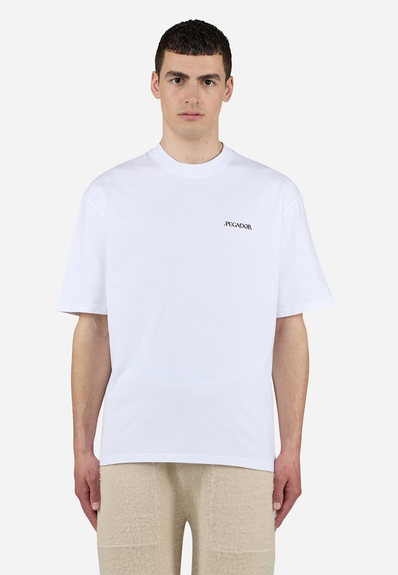 T-shirt bianco in cotone con maniche corte, scollatura a girocollo e un piccolo logo nero sul petto. Trama liscia, vestibilità comoda.