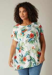 Bluse mit kurzen Ärmeln aus leichtem, weichem Material, versehen mit einem lebhaften tropischen Druck mit roten Blumen und grünen Blättern. Rundhals-Ausschnitt.