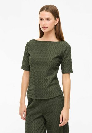 Olive green textured top with a square neckline and short sleeves, featuring a wavy pattern. Paired with matching textured pants.