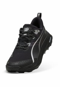 Czarne buty sportowe z teksturowaną siateczkową cholewką, odblaskowymi srebrnymi akcentami i wytrzymałą czarną podeszwą. Posiadają wzorzyste sznurowadła i pętlę do łatwego zakładania.