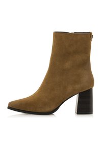 Braune Wildleder-Stiefelette mit spitzem Fuß und blockabsatz, ausgestattet mit einer strukturierten schwarzen Sohle und einem Rückreißverschluss für einfaches An- und Ausziehen.