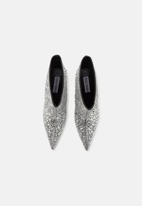 Bottines argentées à bout pointu, recouvertes de petits clous irisés avec un intérieur noir. Présentent une silhouette élégante et un talon haut.