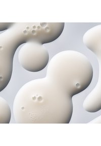 Materiale bianco simile al silicone con forme astratte arrotondate e texture varie, caratterizzato da superfici lisce e piccole bolle o fossette.