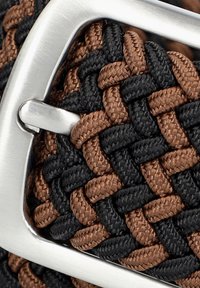 Tkaniany pasek wykonany z czarnych i brązowych włókien syntetycznych z metalową klamrą w kolorze srebrnym. Tekstura jest gładka, z plecionym wzorem.