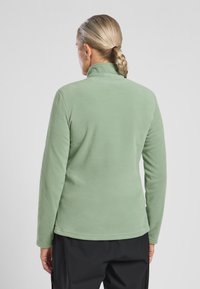Zielony polarowy sweter z wysokim kołnierzem, długimi rękawami i gładką teksturą. Posiada prosty dół i minimalistyczny design, bez zdobień.