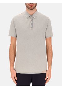 Lichtgrijze polo gemaakt van zachte katoen, met een kraag, een knoopsluiting met drie knopen en oranje accentstiksels op de schouder.