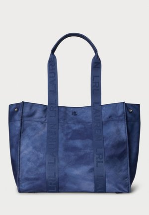 Marineblaue Tragetasche aus strukturiertem Stoff mit zwei stabilen Griffen, die mit geprägten Logo-Gurten und metallischen Akzenten versehen ist.