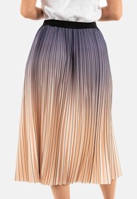 Falda plisada en tonos degradados de púrpura a durazno con una cinturilla negra. Rayas verticales recorren la superficie, añadiendo textura.