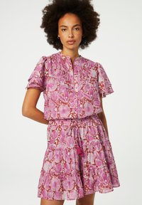 Rosa Kleid mit Muschel-Muster, plissierten Kurzärmeln, einem geknöpften Oberteil und einem gestuften Rock mit Kordelzug in der Taille und Quasten-Detail.