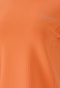Orange Sportshirt mit strukturiertem Gewebe und einem dezenten Muster sowie einem kleinen "ENDURANCE"-Logo in Hellblau auf der Brust.