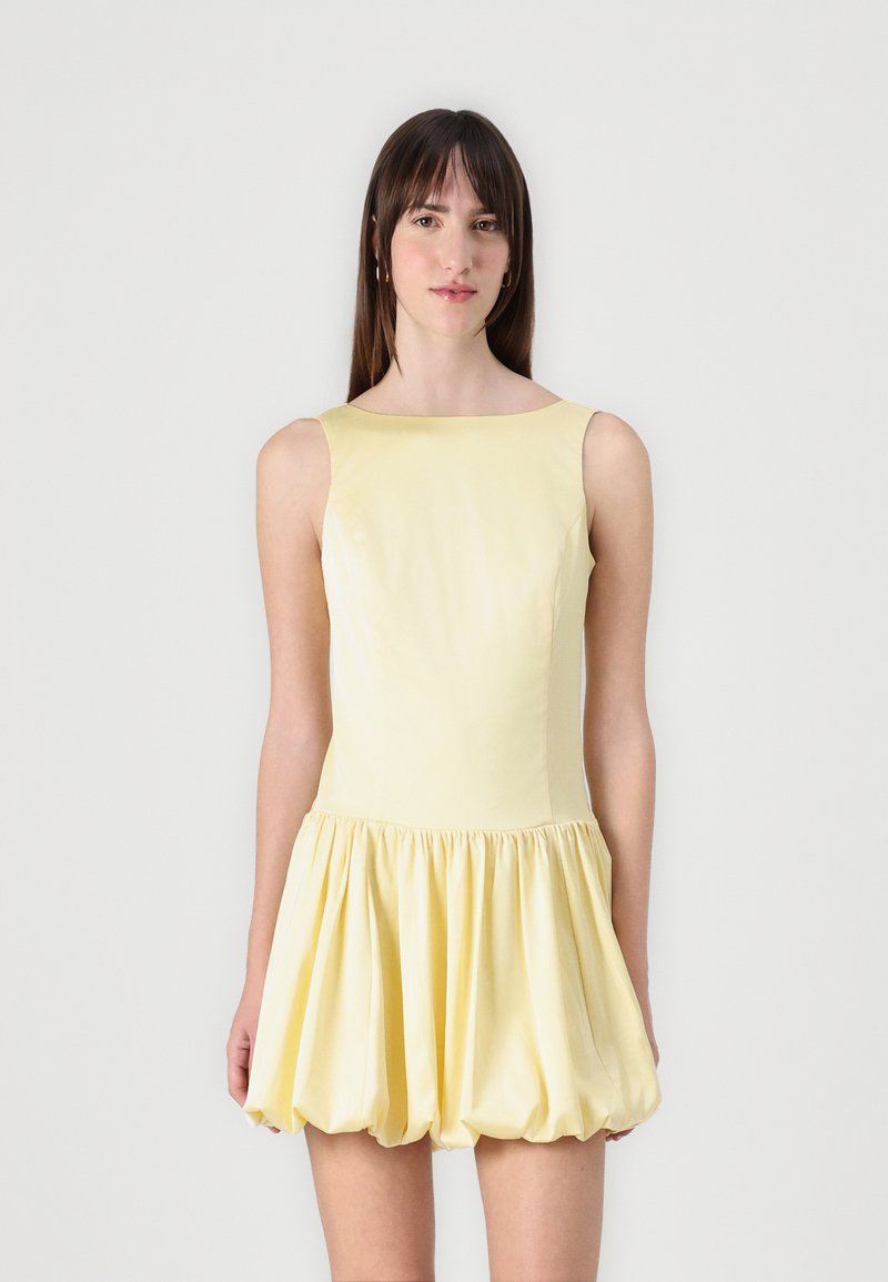 Kollane ilma varrukateta mini-kleid, millel on hästi istuv kehakujundus ja laienev, kokku volditud seelik. Sile tekstuur kerge ja pehme kangaga.