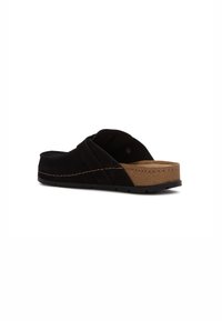 Svarta mocka slip-on sandaler med brun korkfotbädd och svart yttersula, sidovy på vit bakgrund.