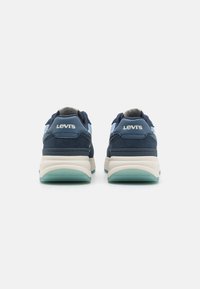 Sötétkék sportcipő velúr és hálós felsőrészével, fehér középtalppal és áttetsző zöld gumitalppal. "Levi's" logó a sarokrészen.