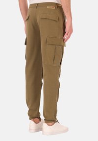 Olijfgroene cargobroek met zijzakken, taps toelopende boorden en een comfortabele pasvorm. Gemaakt van zachte stof, met een label aan de taille.