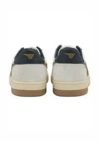 Sneakers da uomo con tomaia in suede grigio chiaro, tallone blu scuro e suola in gomma beige. Dettaglio del logo dorato sul tallone.