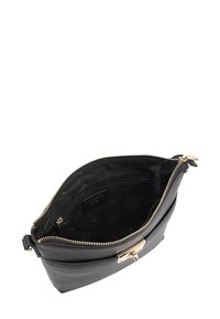 Zwarte lederen tas met een ritssluiting, gouden hardware en een textuur aan de buitenkant. De binnenkant bevat een ritszak.