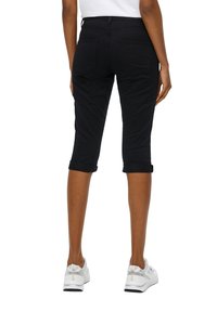 Pantalons courts noirs en denim. Présentent des ourlets roulés, deux poches arrière et une coupe sleek qui se termine juste en dessous du genou.